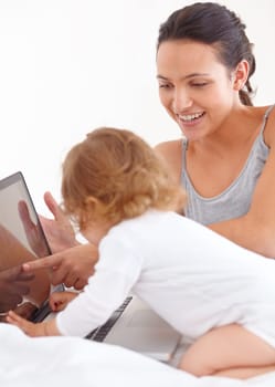 Learning, baby and smile of mother on laptop in bedroom for online education or remote work in home. Freelancer mom, computer and point to kid on internet, show toddler screen and family together.