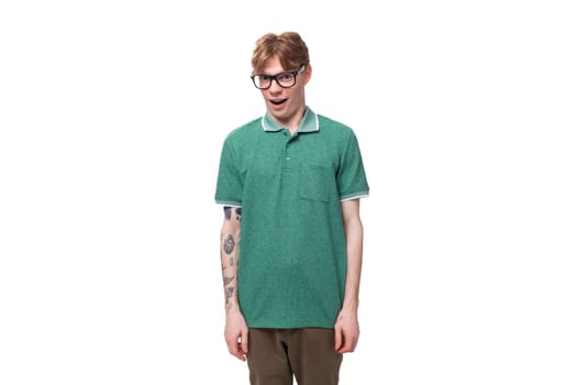young caucasian red-haired man dressed in a green t-shirt yawns and thinks over a solution.