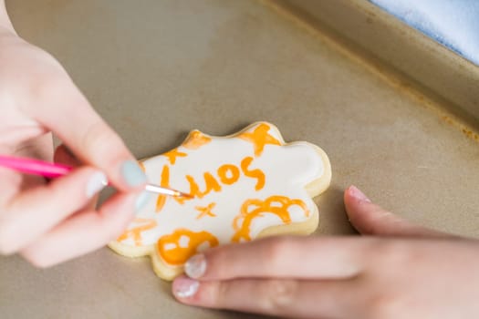 A heartwarming scene of a little girl carefully writing 'Sorry' on sugar cookies with food coloring, the cookies beautifully flooded with white royal icing.