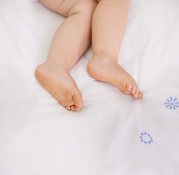Baby sleeping, feet and top view on bed to relax, comfort and calm at home on mockup space. Toddler, above and closeup of cute foot, legs of adorable child and young kid resting in peace in bedroom.