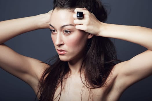 Beauty, makeup and face of woman with hair in studio, hairstyle and shine on dark background. Portrait, cosmetic care glow on skin with dermatology, haircare and texture with growth and jewellery.