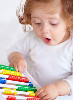 Abacus, surprise and girl baby learning, playing and teaching for child development on bed. Maths, toy and closeup of young kid, infant or toddler counting for education in bedroom at modern home