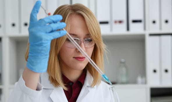 Technician hold in arms in protective gloves sample bottle with poison fluid portrait. Medical worker in uniform use reagent tube for virus infection exam or biological toxic reaction drug creation