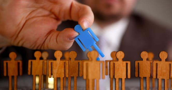 Man arm in suit take little plastic toy figure out of crowd closeup. Fire one worker hr job shift head hunter inspector rare disease unit dismissal retire lgbt media virus epidemic success concept