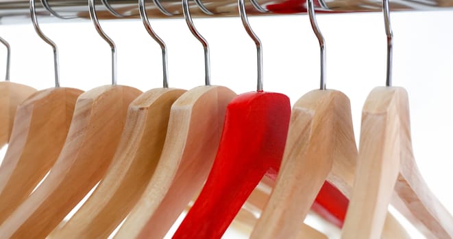 Red and wooden hanger hanging on metal pipe business leader selling clothes and style