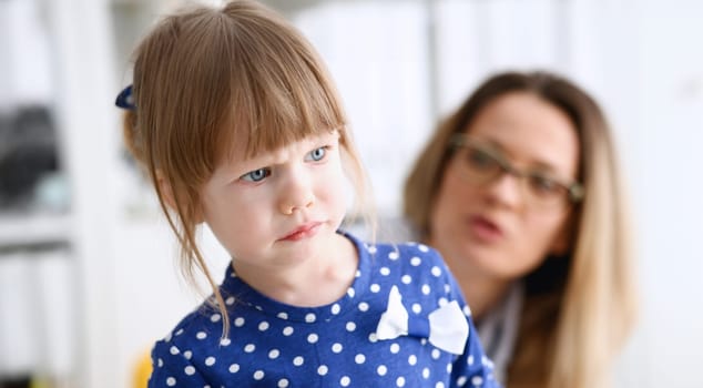 A small child is afraid in the hospital room. The doctor holds his hands and soothes the portrait.