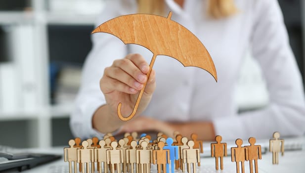 Smiling Business woman in hand holds a miniature umbrella in the hand of the topic of liability insurance