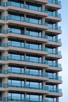 glass facade of a modern residential skyscraper with balconies.