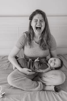 Vertical photo. A woman holds a child in her arms and cries. Postpartum depression