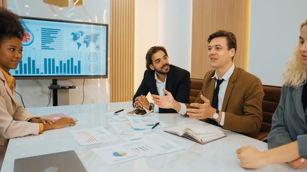 Analyst team utilizing BI Fintech to analyze financial data at table in ornamented meeting room. Businesspeople analyzing BI dashboard power for business insight and strategic marketing planning.