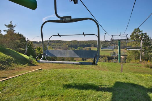 Chairlifts at ski resort in fall with no snow and lots of grass. High quality photo