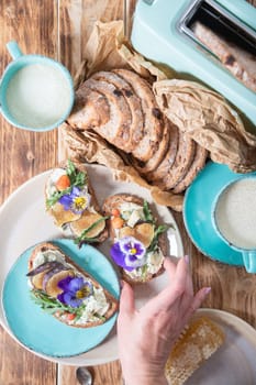 delicious bruschetta with homemade bread, garnished with fig,soft cheese,pansies, top view. High quality photo