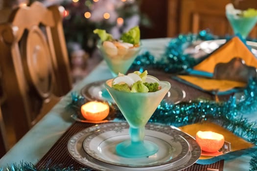 Festively served table, anticipation of Christmas, sea salad in turquoise bowls. High quality photo