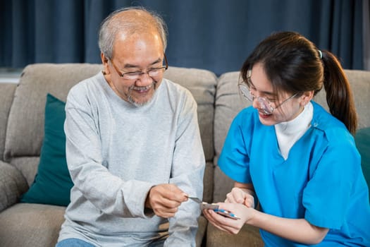 Asian doctor with physician visit senior male patient consult medicine dosage at house in living room, Woman nurse caregiver showing prescription drug to senior man at nursing home, healthcare support