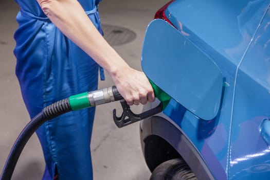 Woman pouring gasoline into her hybrid car at a gas station,evening lighting lamps, High quality photo