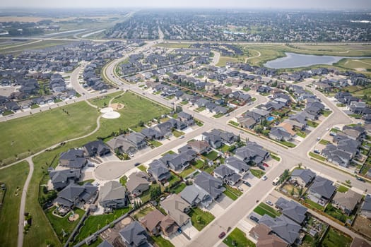 Elevated drone view of Rosewood, Saskatoon, showcasing its residential layout, green areas, and vibrant community life.