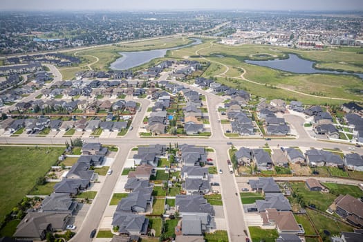 Elevated drone view of Rosewood, Saskatoon, showcasing its residential layout, green areas, and vibrant community life.