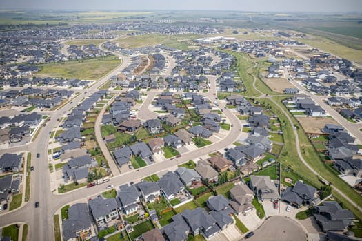 Elevated drone view of Rosewood, Saskatoon, showcasing its residential layout, green areas, and vibrant community life.