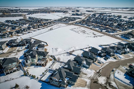 Elevated drone view of Rosewood, Saskatoon, showcasing its residential layout, green areas, and vibrant community life.