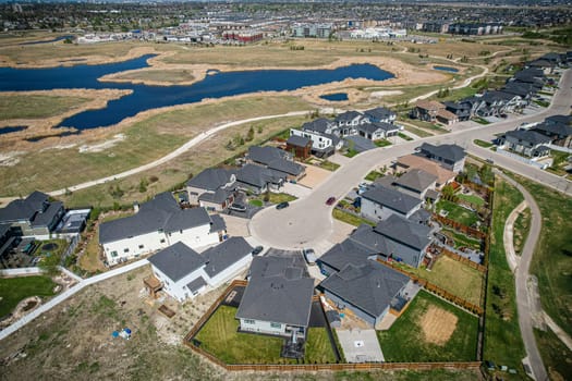 Elevated drone view of Rosewood, Saskatoon, showcasing its residential layout, green areas, and vibrant community life.