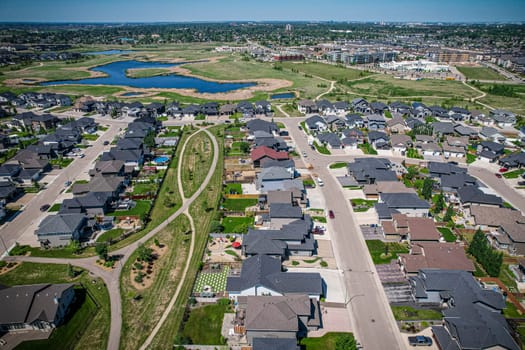 Elevated drone view of Rosewood, Saskatoon, showcasing its residential layout, green areas, and vibrant community life.