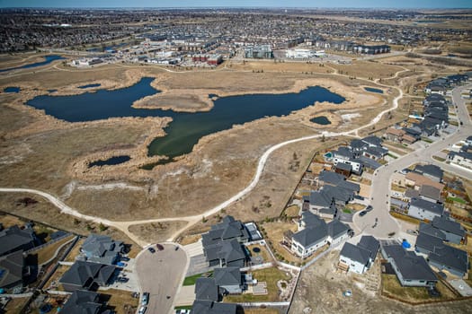 Elevated drone view of Rosewood, Saskatoon, showcasing its residential layout, green areas, and vibrant community life.