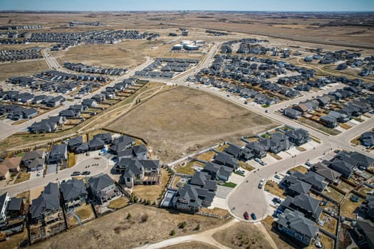 Elevated drone view of Rosewood, Saskatoon, showcasing its residential layout, green areas, and vibrant community life.