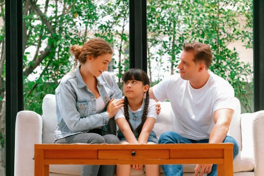 Parents comforting their daughter with loving hug, helping her feel secure and protected from fear, rest her head on shoulder. Happy family love and child care support concept. Synchronos