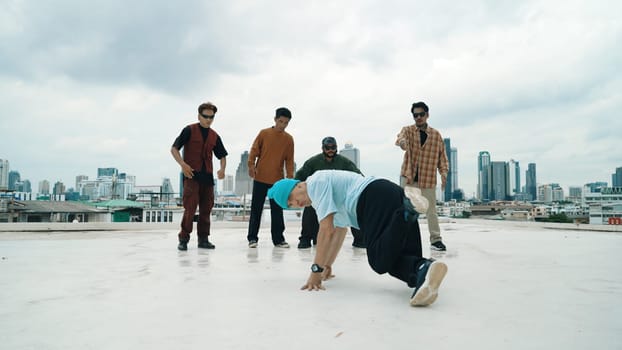 Professional break dance team practice B-boy dance while multicultural friends at rooftop. Young modern dancing group doing hip hop movement. Style,fashion,action. Outdoor sport 2024. Endeavor.