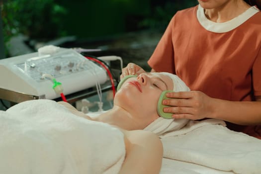 Attractive caucasian woman receive electrical facial treatment. Beautiful girl lies on spa bed while having medical treatment from professional doctor from medical spa center. Tranquility.