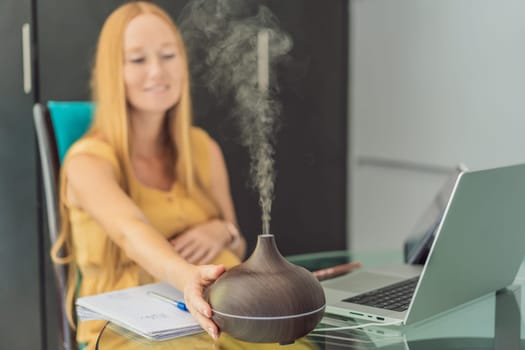 Expectant woman enhances work environment, using an aroma diffuser for a soothing atmosphere during pregnancy.