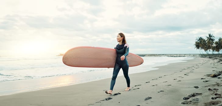 Woman, surfing board and walking on sand at beach, sea and ocean for summer holiday, travel adventure and happiness. Japanese surfer on shore for water sports, freedom and relax for tropical vacation.