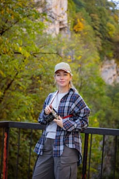 Young photographer enjoying the view of a mountain gorge, capturing it in the camera lens