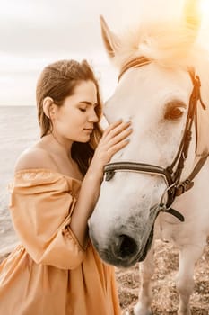 A woman in a dress stands next to a white horse on a beach, with the blue sky and sea in the background