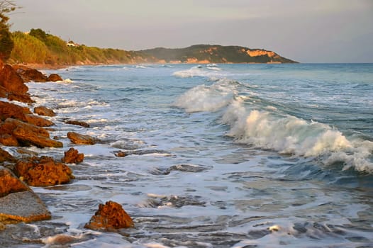 Sea at sunset with waves on the beach. Greece - the island of Corfu.