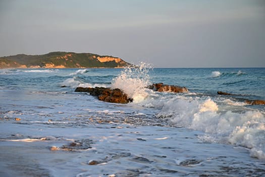 Sea at sunset with waves on the beach. Greece - the island of Corfu.