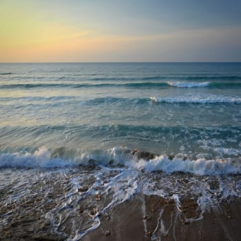 Sea at sunset with waves on the beach. Greece - the island of Corfu.