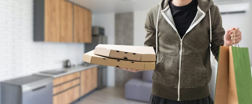 Young handsome delivery man holding paper bag with takeaway food happy with big smile