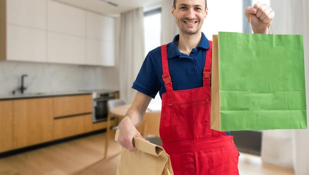 Young handsome delivery man holding paper bag with takeaway food happy with big smile