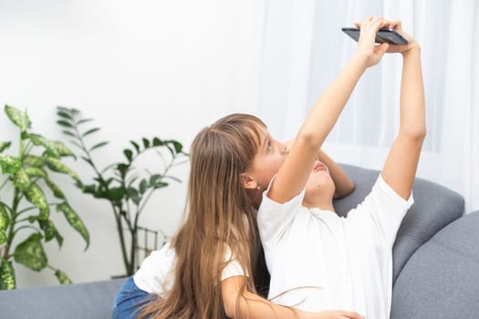 people, technology and friendship concept - happy teenage girls taking selfie with smartphone sitting on sofa at home. High quality photo