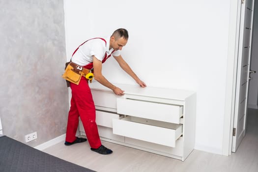 Professional furniture assembly and repair concept. Contractor repairman assembling furniture, indoors. High quality photo