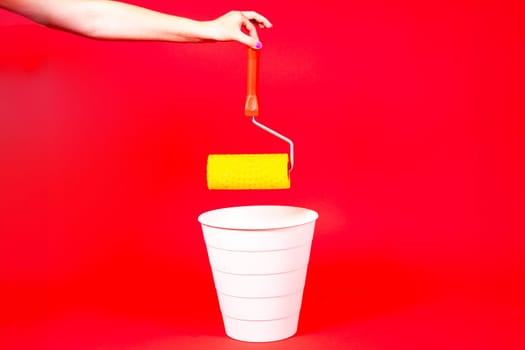 Construction roller is thrown into the trash on red background