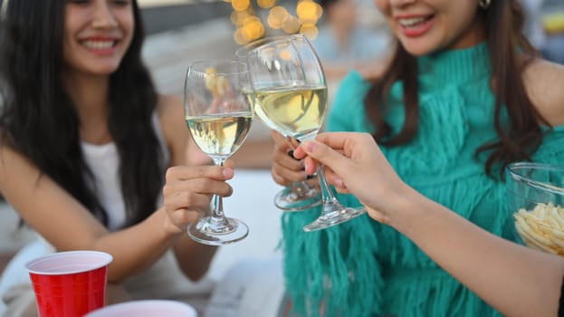 Group of cheerful people having fun while toasting with alcohol on a rooftop party.