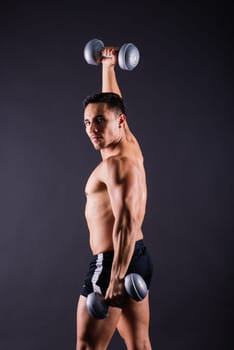 Portrait young fitness sporty strong man barechested muscular sportsman isolated on grey dark.