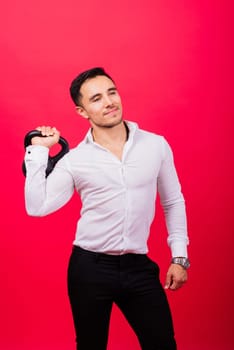 Attractive businessman Exercising With Kettlebell In a studio, red background