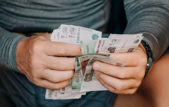 Male Hands Count Money, the Currency is the Russian Ruble. Economy and Finance, Investments. Paper Banknotes. Close-up, Unrecognizable Person, Top View