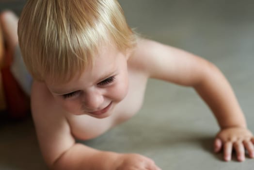 Baby, playing on floor outdoor for development with relax, curiosity and early childhood in backyard of home. Toddler, child and crawling on ground for wellness, milestone or exploring with innocence.