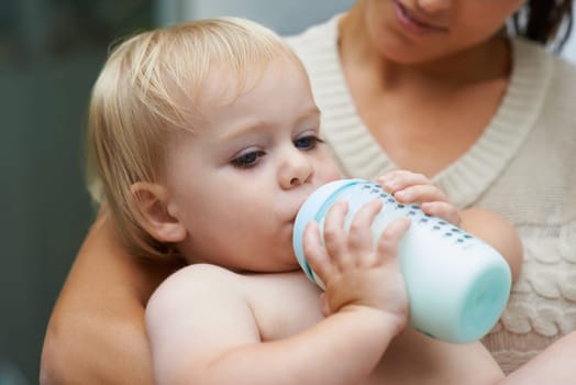 Relax, cute and baby drinking bottle and laying with mother with milk for bonding together. Growth, sweet and infant, kid or toddler enjoying a beverage for nutrition, health and child development