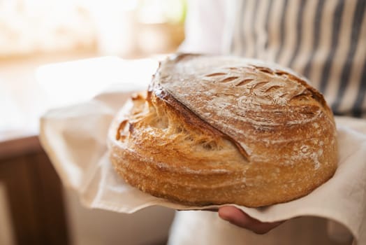 Just baked bread in hands of a woman