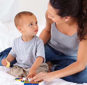 Abacus, bonding and baby with mother playing, learning and teaching for child development on bed. Math, toy and closeup of mom helping kid, infant or toddler with counting in bedroom at home